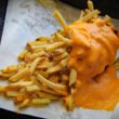 Thin French fries are topped with molten orange cheese