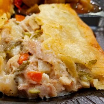 Chicken, gravy, and vegetables tumble from under the savory crust in which they were baked