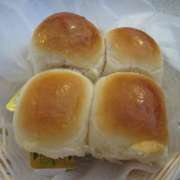 Quartet of soft, round-top dinner rolls, still stuck together from the bake-pan