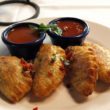 Four empanadas with spicy dipping sauces