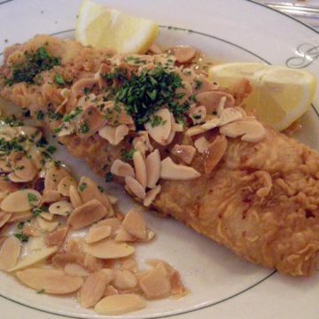 Crisp-fried trout scattered with slivered almonds: trout amandine