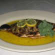 Whole broiled pompano in a pool of lemon-butter sauce fills a deep plate