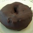 Chocolate donut is completely enrobed in dark chocolate icing