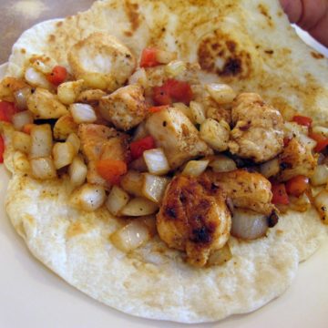 Extra-large tortilla holds grilled chicken and festive-colored salsa