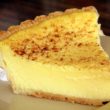 Bright yellow wedge of custard pie is sprinkled with nutmeg