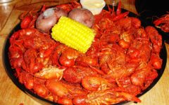 An immense pan of boiled crawfish is garnished with corn-on-the cob and a couple of boiled potatoes.