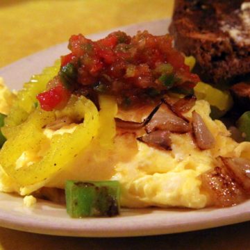 Scrambled eggs laced with peppers and onions, topped with salsa