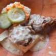 Biscuit is topped with sausage as well as fried chicken and pimento cheese