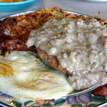 Gravy-smothered chicken fried steak with eggs and hash browns