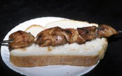Skewered chunks of marinated grilled lamb resting on a piece of white bread