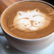 Cup of rich, creamed espresso with a cat-head design on top, made of cream