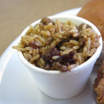 A cup of dirty rice is packed with chunks of spicy andouille sausage
