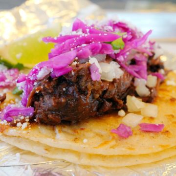 Taco loaded with short rib, pink pickled cabbage, cheese & onion