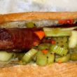 Crusty grilled sausage occupies a long bun with a great spill of giardiniera (pickled vegetables)