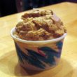 Small paper cup holds golden-tan scoop of burnt sugar-flavored ice cream