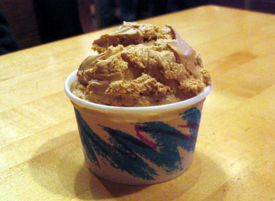 Small paper cup holds golden-tan scoop of burnt sugar-flavored ice cream