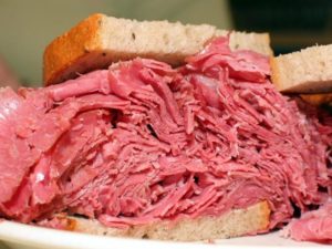 Thin-sliced corned beef is piled high between slices of rye bread.
