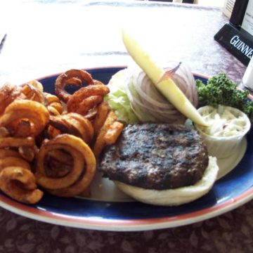 Well-garnished buffalo burger shares plate space with curly fries