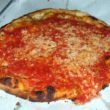 Char-crust New Haven pizza topped with crushed tomatoes and a bit of grated cheese... but no mozzarella