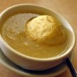 One huge matzoh ball floats in a bowl of chickeny broth.