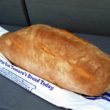 Bakery-fresh loaf of Italian bread, resting on the bag it was sold in