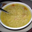 Golden broth packed with little noodles and strips of chicken meat