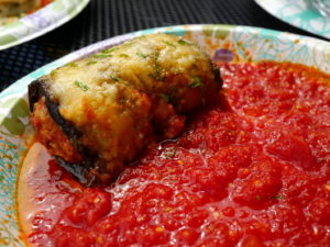 Eggplant baked around seasoned veal, topped with melted cheese, in a pool of fruity tomato sauce
