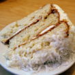 3-layer coconut cake is slatered with frosting that bristles with shreds of coconut