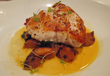 Grilled grouper steak sits atop roasted turnips in a golden pool of saffron-citrus butter