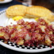 On a diner's breakfast plate: corned beef sizzled with tender potatoes and sweet onions