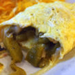 Close view of omelet wrapped around hot green chilies and cheese