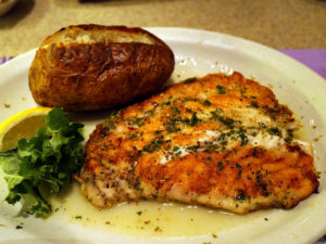 Griddle-crisped snapper steak, bright with spice and herbs, lolls in lemon & olive oil on a plate with a baked potato