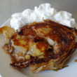Apple strudel, sliced and grilled in butter, topped with whipped cream