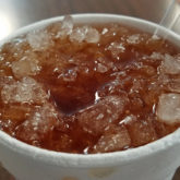 Styrofoam cup of tea is crowded with chopped ice