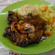Moist jerk chicken, plastered with spices, comes with rice and cabbage
