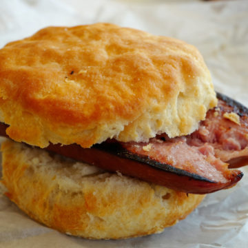 Creamy buttermilk biscuit sandwiches a bisected smoky sausage link