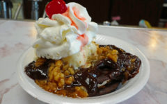 In a paper bowl, a moon pie is the foundation for ice cream, hot fudge, wet walnuts, whipped cream, and a cherry.