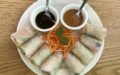 Tightly packed Thai salad rolls accompanied by peanut and soy-based sauces.