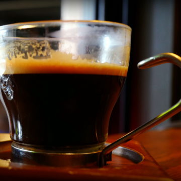 Glass cup of dark, dark espresso with a slightly foamy head