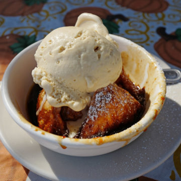 Bowl holds a crisp-crusted apple dumpling and a scoop of caramel apple ice cream