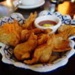 Plate of crisp-fried wontons accompanied by sweet dipping sauce
