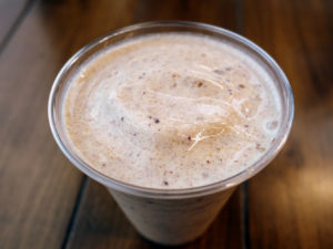 Overhead view of a thick milk shake crowded with bits of date