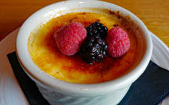 Crisp-topped creme brulee is topped with fresh berries