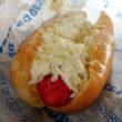 Bright red bunned weenie topped with creamy cole slaw