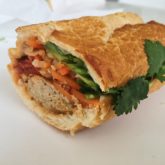Banh mi sandwich contains meatballs, crisp veggies, and spicy marinara sauce