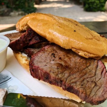 Dark, juice-heavy slices of tri-tip beef spill out of the bun that holds them