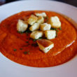 Pink tomato soup topped with crisp, cheey croutons