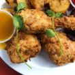 Fried chicken on a plate with microgreens and dipping sauces