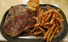 T-bone steak & French fries on a hot platter