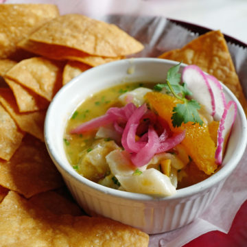 Cup of halibut ceviche is flavored with orange and sweet pickledonion.